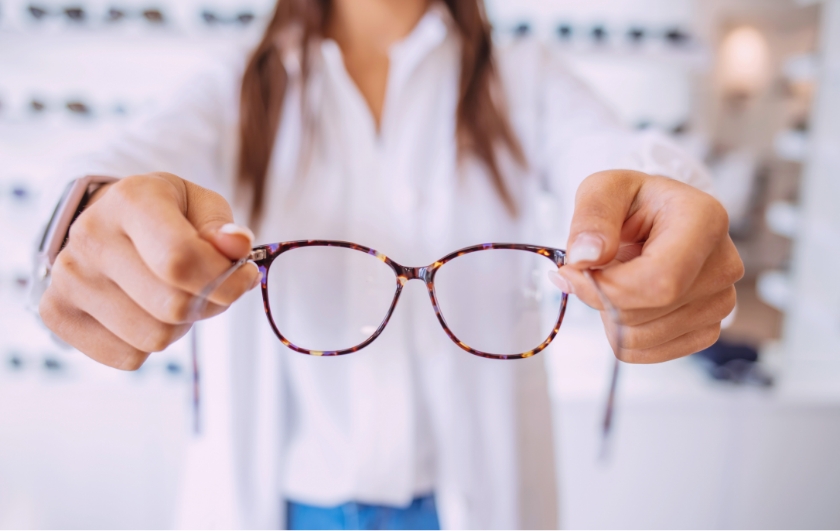 person holding sunglasses towards camera