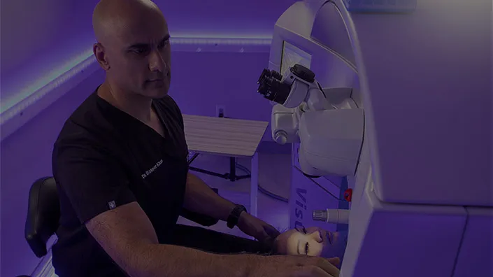 Doctor sitting adjusting settings on microscope
